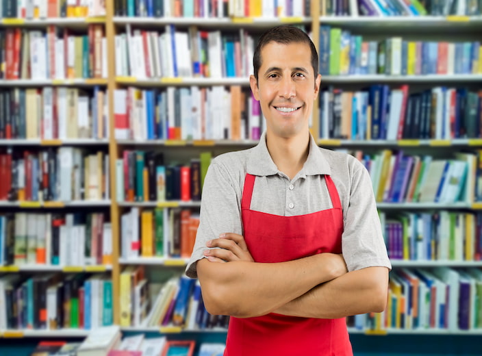 Un libraire souriant croise les bras