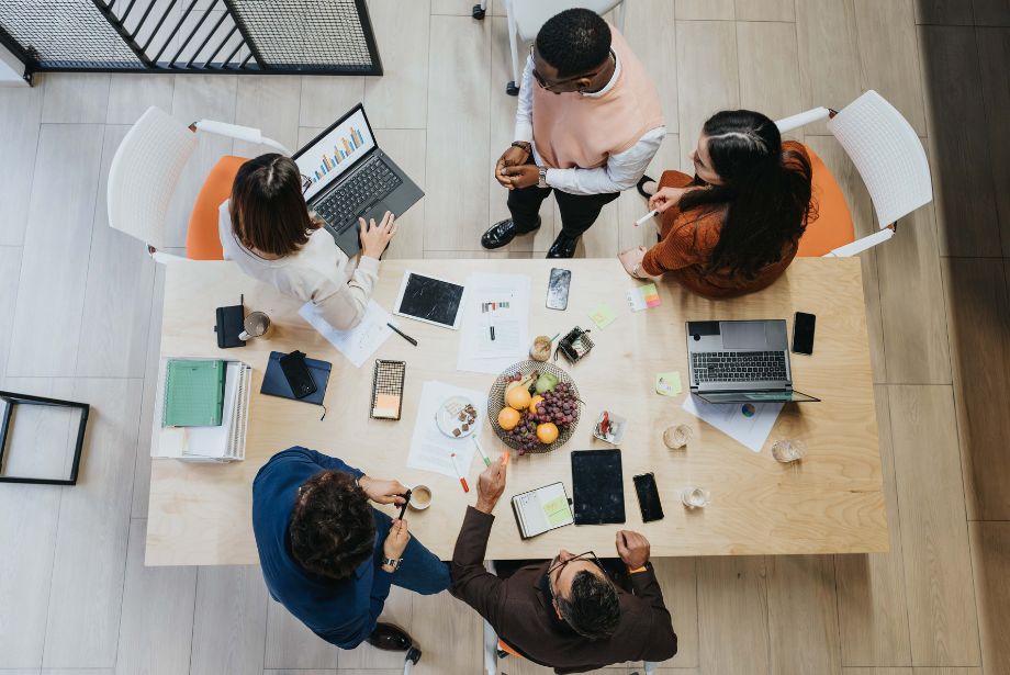 Cinq salariés en atelier de travail autour d'une table