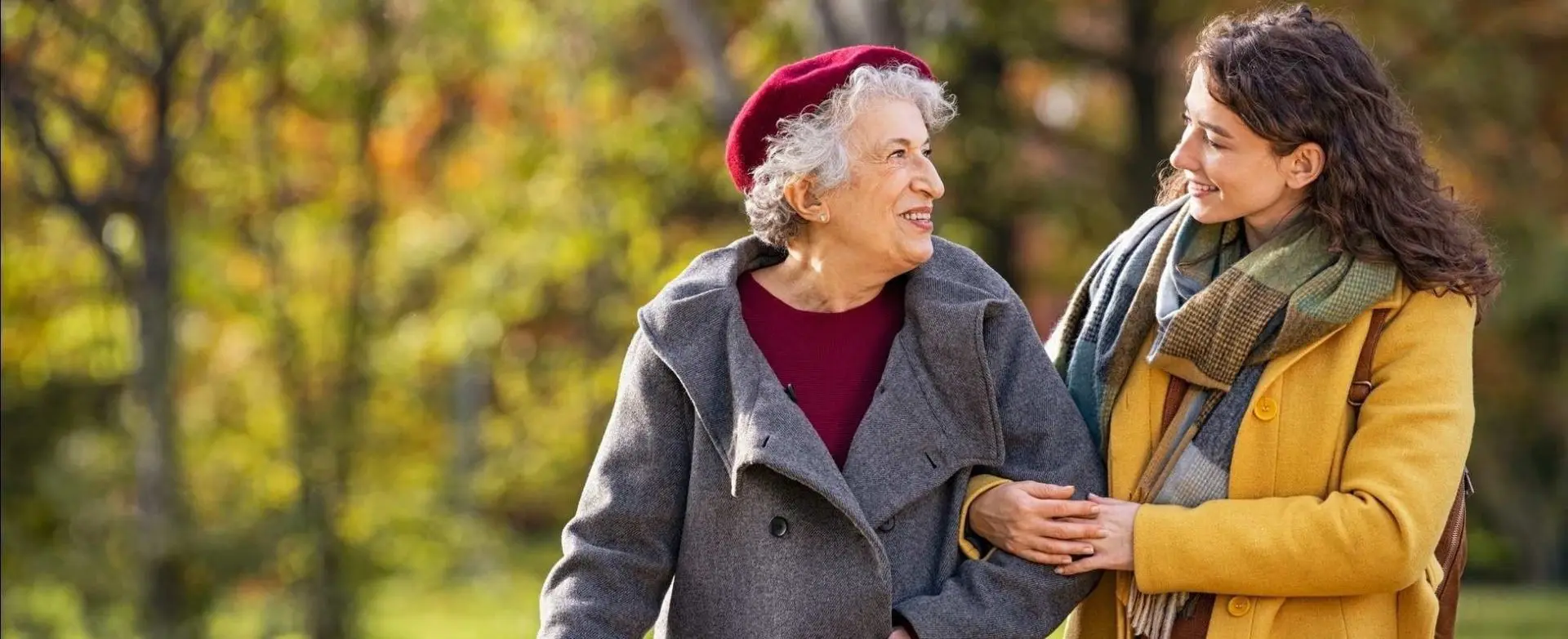 Photo d'une personne âgée accompagnée d'une jeune femme dans un parc